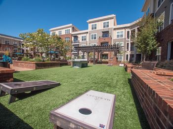 Outdoor exercise area with ping pong table and cornhole boards